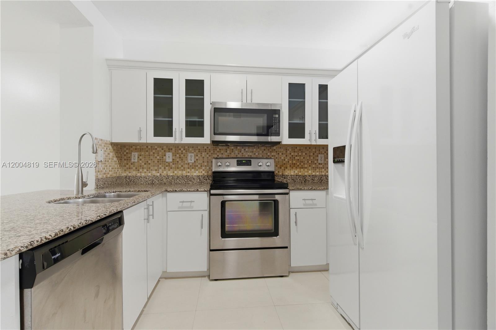 3725 Southwest 153rd Court Miami, FL 33185 - Photo 10 of 28 a kitchen with granite countertop a stove and a sink