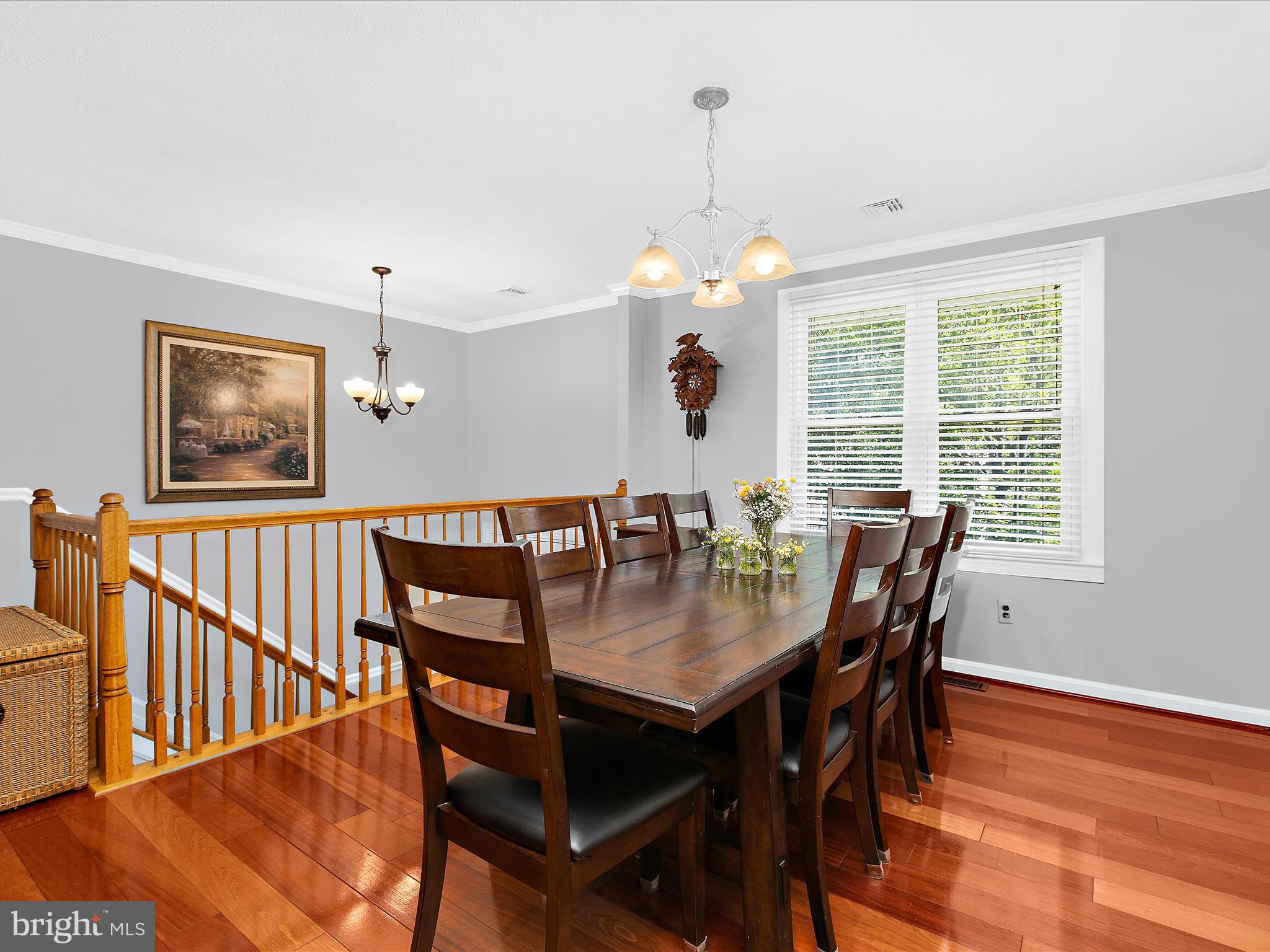 1217 Somerset Road Severn, MD 21144 - Photo 11 of 86 a view of a dining room and livingroom with furniture wooden floor a rug a painting and a chandelier