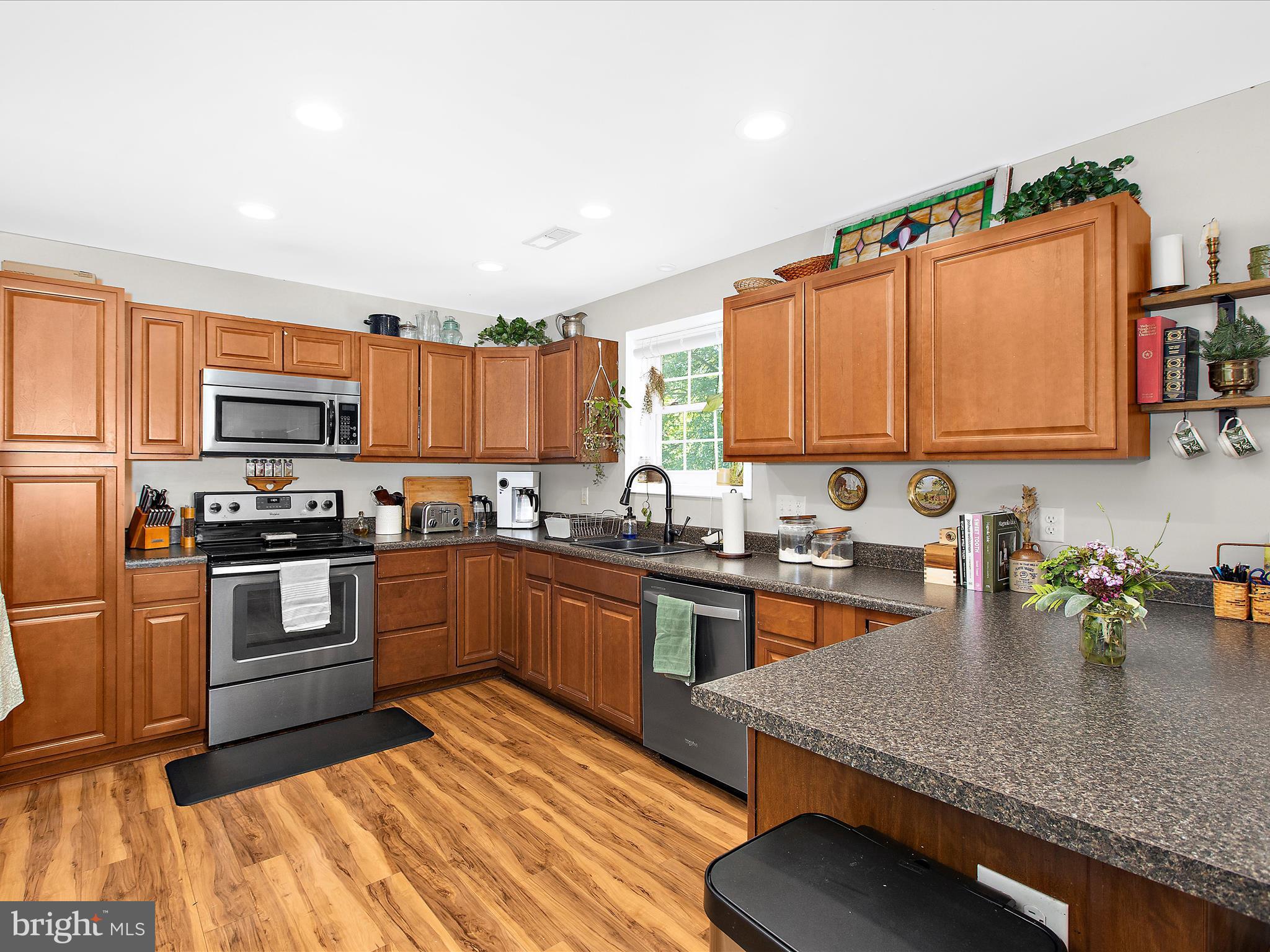 1217 Somerset Road Severn, MD 21144 - Photo 48 of 86 a kitchen with stainless steel appliances granite countertop a stove a sink dishwasher and a microwave oven with white cabinets