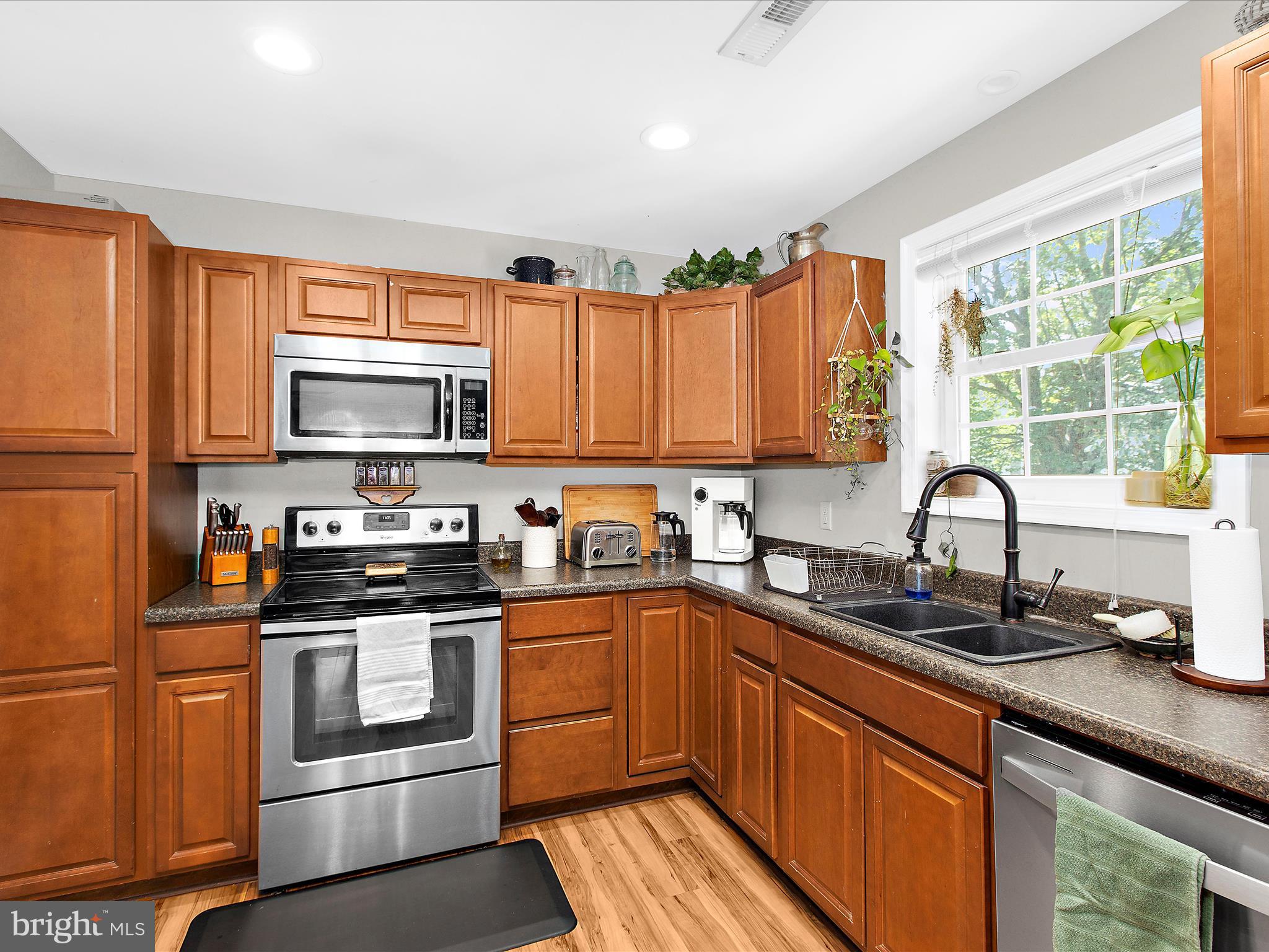 1217 Somerset Road Severn, MD 21144 - Photo 49 of 86 a kitchen with kitchen island granite countertop a sink stainless steel appliances and cabinets