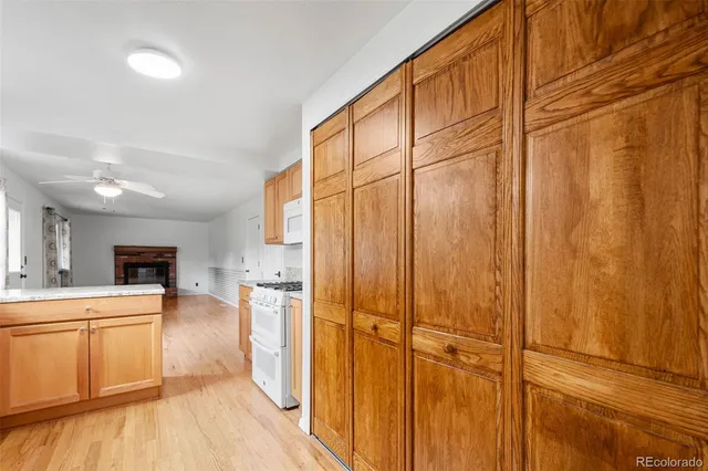 a large kitchen with a refrigerator a stove top oven a sink and dishwasher with wooden floor