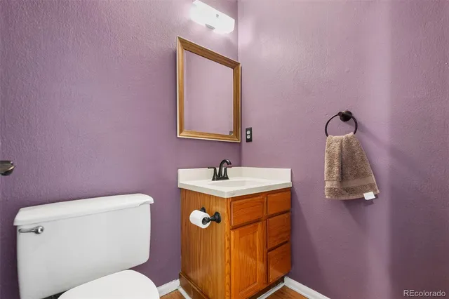 a bathroom with a toilet sink vanity and mirror