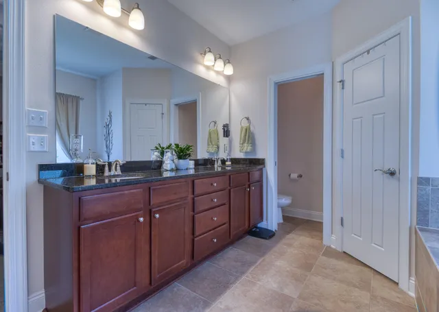 a spacious bathroom with a granite countertop sink and a mirror