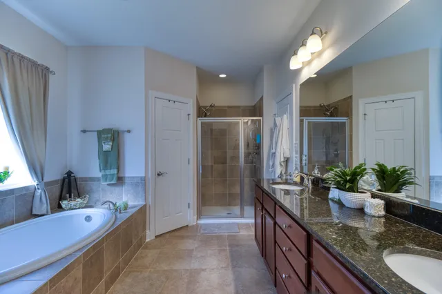 a large bathroom with a granite countertop tub a double vanity sink and a large mirror