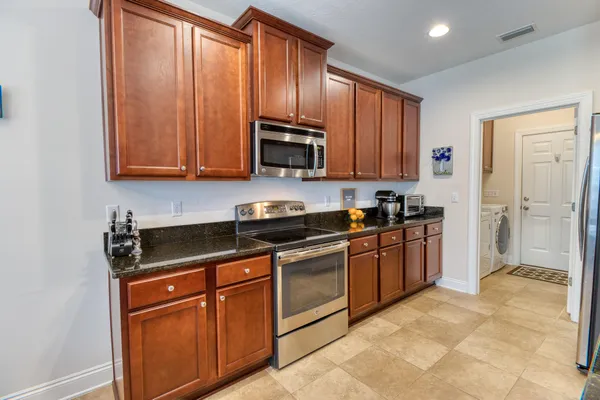 a kitchen with granite countertop wooden cabinets stainless steel appliances and a window
