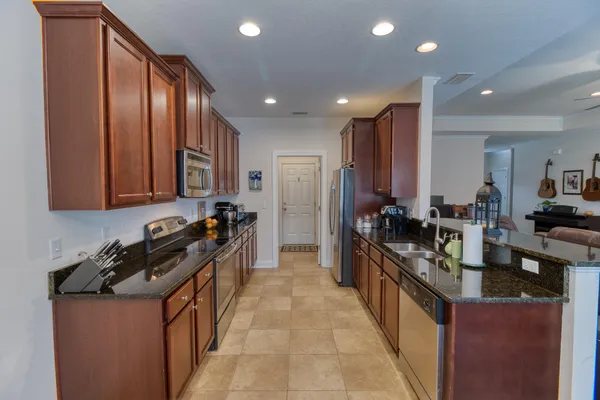 a kitchen with stainless steel appliances granite countertop a stove a sink and a refrigerator