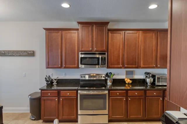 a kitchen with stainless steel appliances granite countertop a stove a sink dishwasher and a microwave oven with cabinets