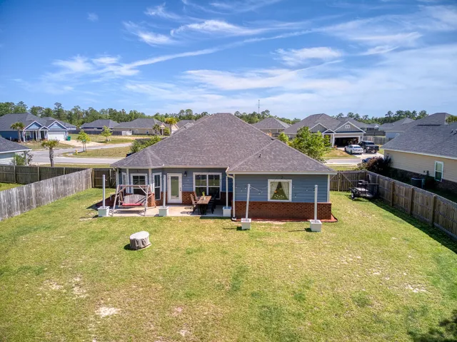 a view of a house with pool and chairs in front of house