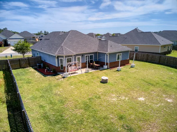 a view of a house with a big yard and a large tree