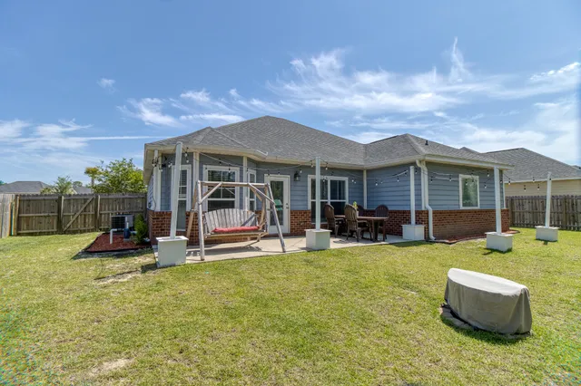 a view of a house with a patio and a yard