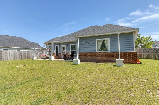 a view of a house with pool and chairs