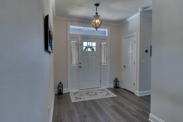 a view of a hallway with wooden floor and a bathroom