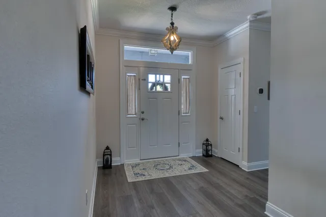 a view of a hallway with wooden floor and a bathroom