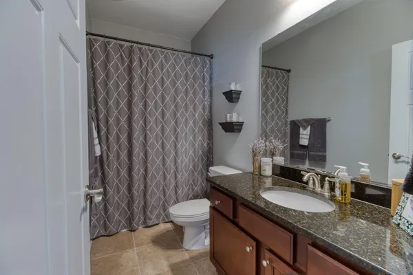 a bathroom with a granite countertop sink and a mirror