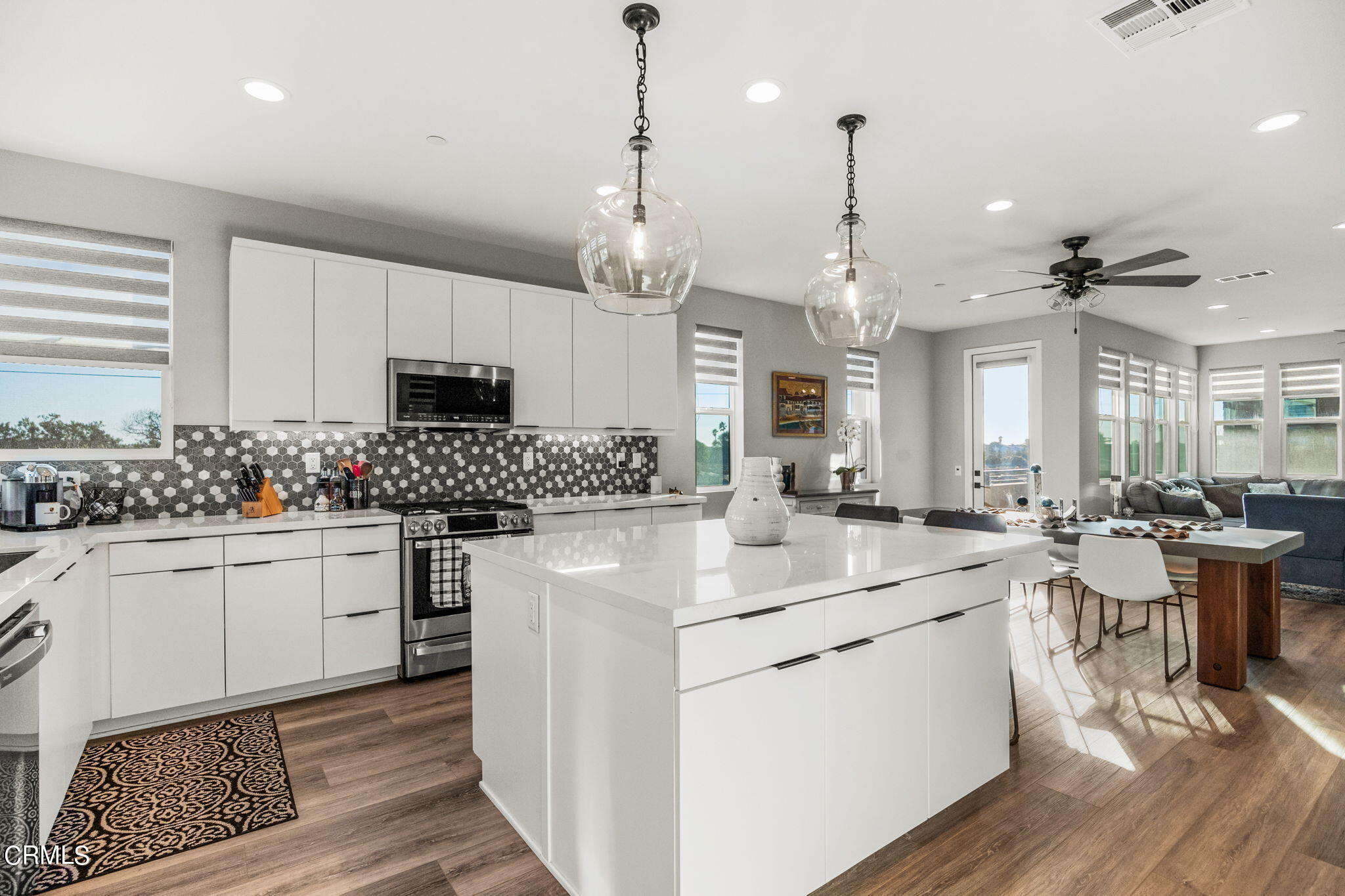 1051 Canal Street Oxnard, CA 93035 - Photo 21 of 54 a kitchen with sink stove and white cabinets with wooden floor