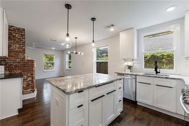 a kitchen with stainless steel appliances granite countertop a stove a sink and a microwave