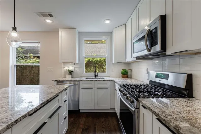 a kitchen with stainless steel appliances a refrigerator a washer and dryer