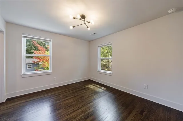 a view of an empty room with wooden floor