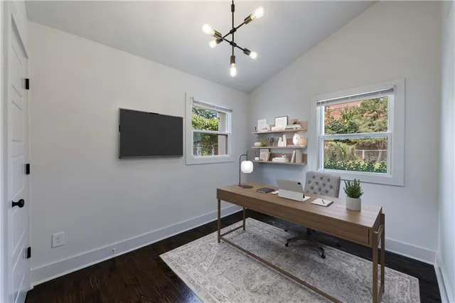 an empty room with wooden floor cabinet and windows