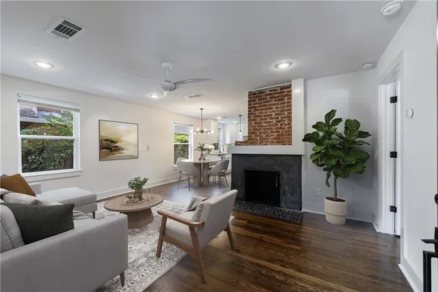 an empty room with wooden floor fireplace and windows