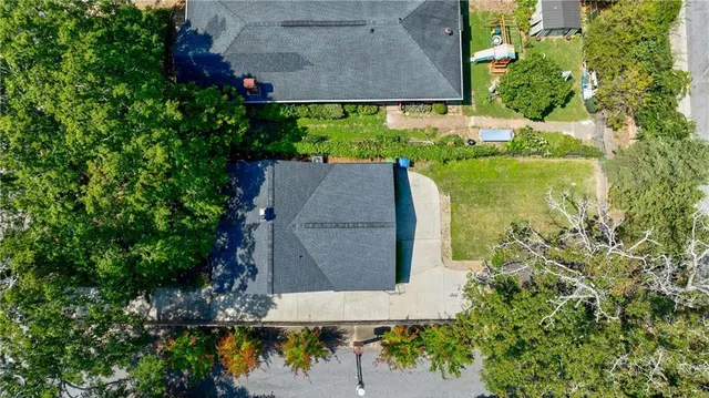an aerial view of a residential houses with outdoor space and trees