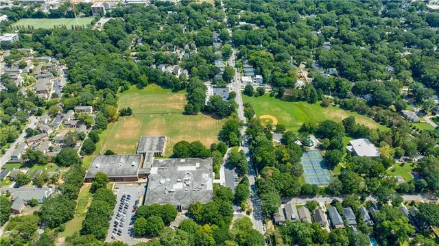 an aerial view of a residential houses with yard and green space