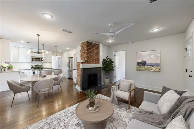 a open kitchen with a refrigerator a fireplace and wooden floor