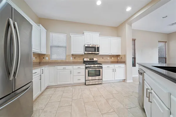 a kitchen with cabinets stainless steel appliances and a counter space