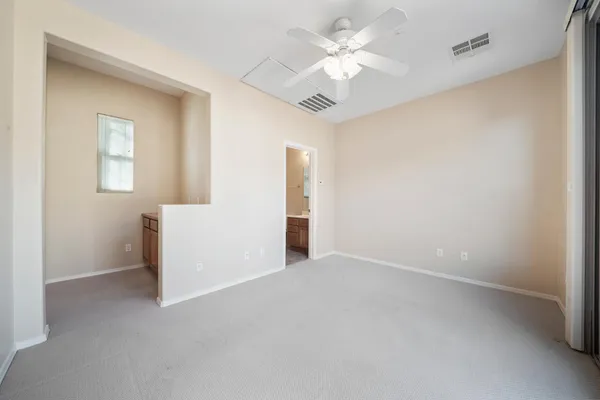 an empty room with a ceiling fan and a window
