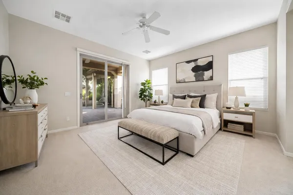 a spacious bedroom with a bed a mirror and a window
