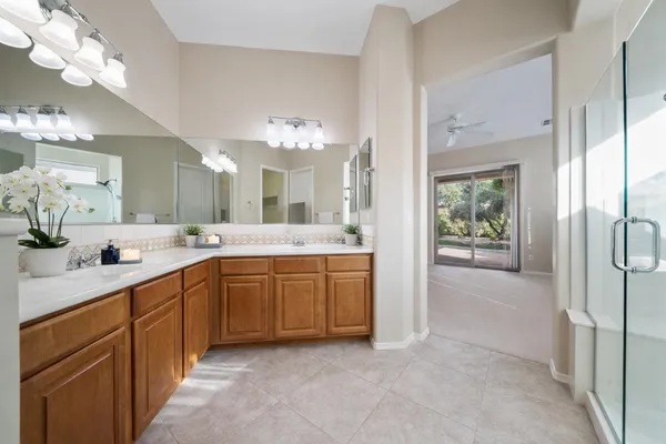 a spacious bathroom with a granite countertop sink a mirror and a bathtub