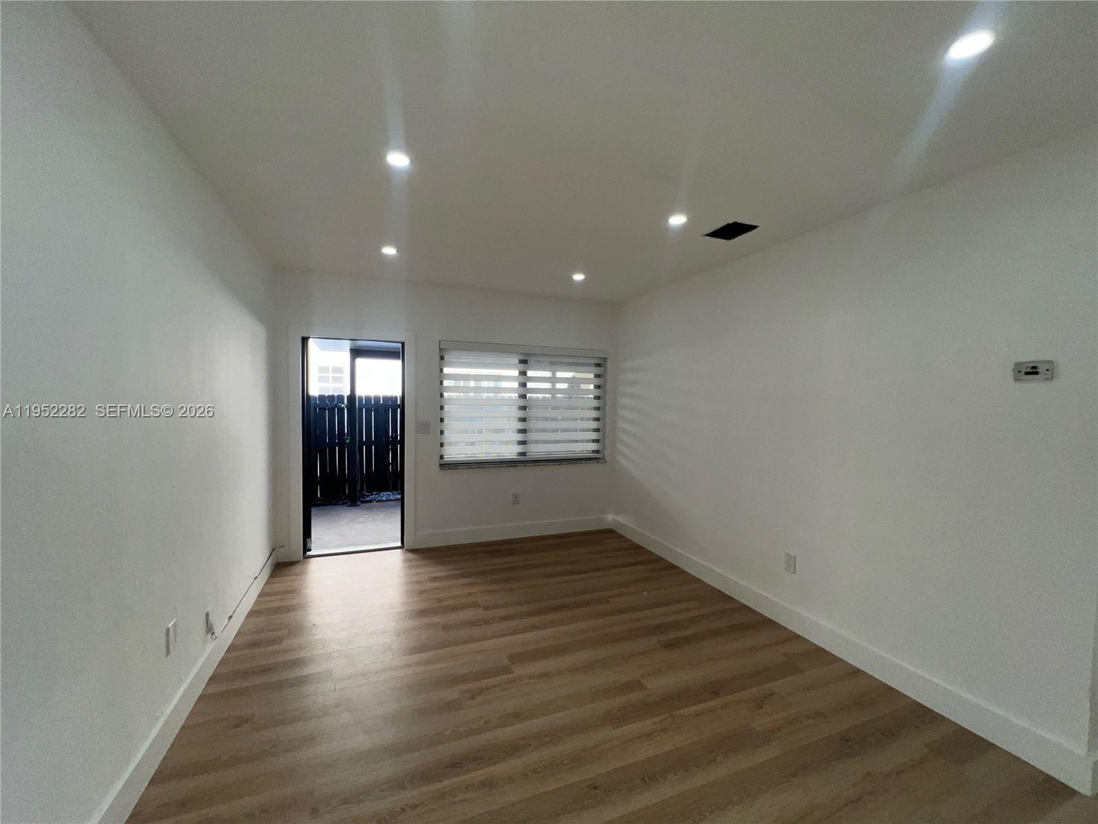 3297 Southwest 26th Street, Unit 3297 Miami, FL 33133 - Photo 14 of 20 wooden floor in an empty room with a window