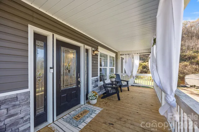 a kitchen with stainless steel appliances kitchen island granite countertop a refrigerator a stove a microwave oven a sink with island and chairs with wooden floor