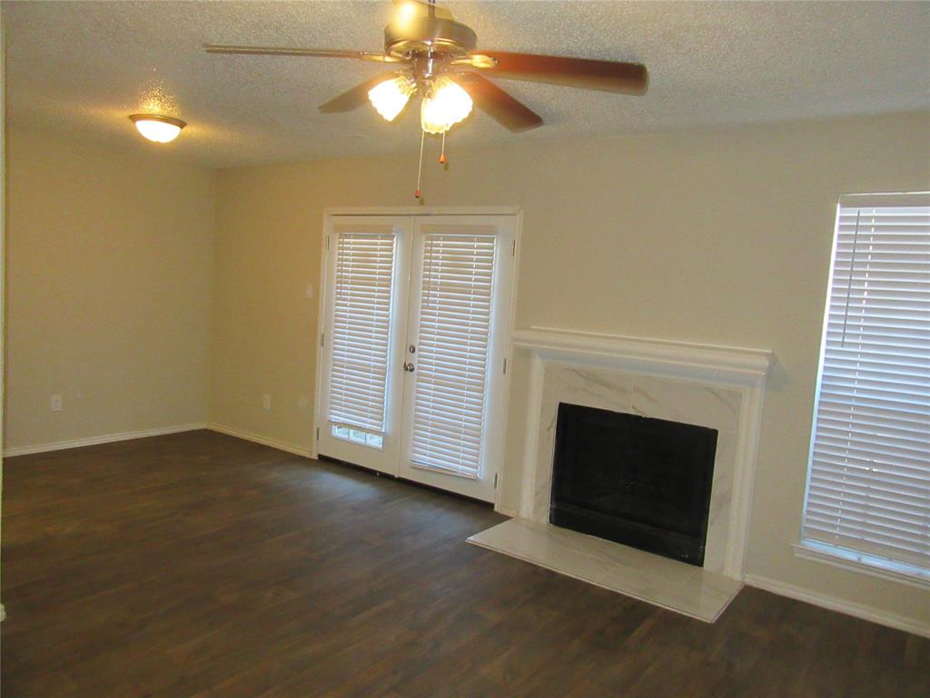 11311 Audelia Road, Unit 241 Dallas, TX 75243 - Photo 2 of 11 an empty room with windows fireplace and fan