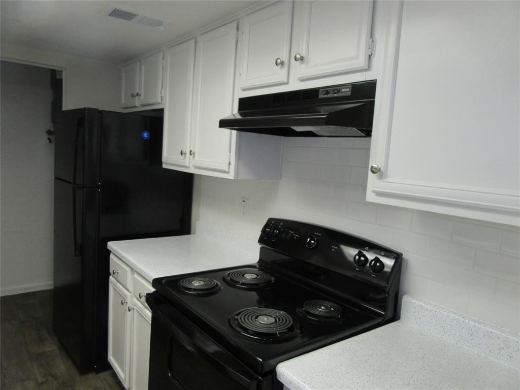 11311 Audelia Road, Unit 241 Dallas, TX 75243 - Photo 3 of 11 a kitchen with stainless steel appliances granite countertop white cabinets and black stove top oven with granite countertops