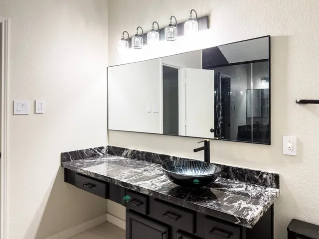 a bathroom with a granite countertop sink and a mirror