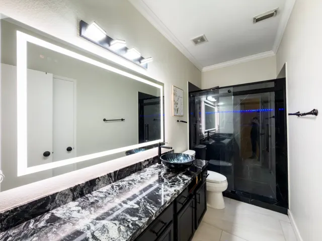 a bathroom with a granite countertop sink and a mirror
