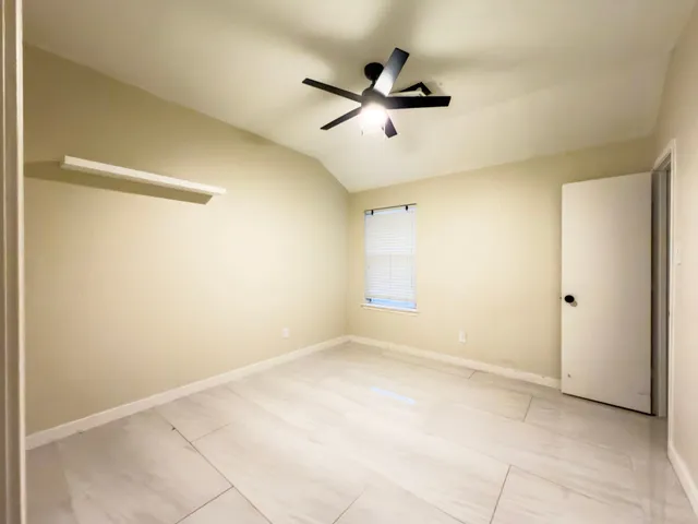 a view of a room with a ceiling fan and a window