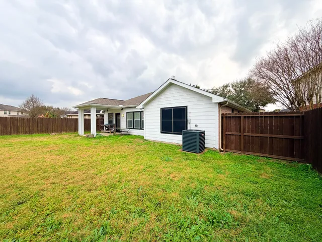 a view of a house with a yard and sitting area