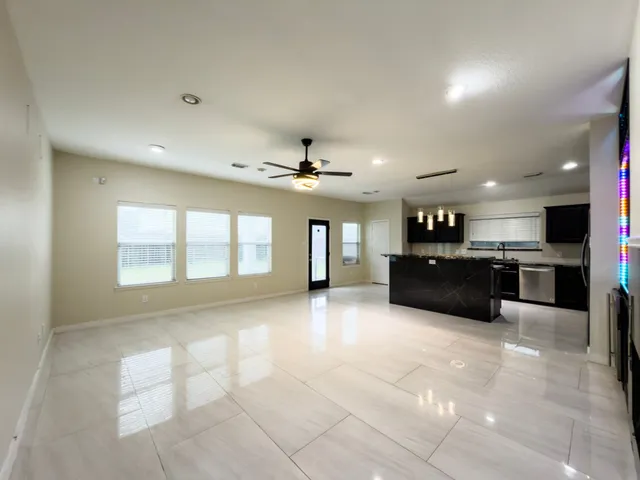 a large white kitchen with kitchen island a sink stainless steel appliances and cabinets