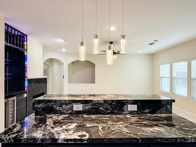 a large kitchen with kitchen island granite countertop a sink and a stove