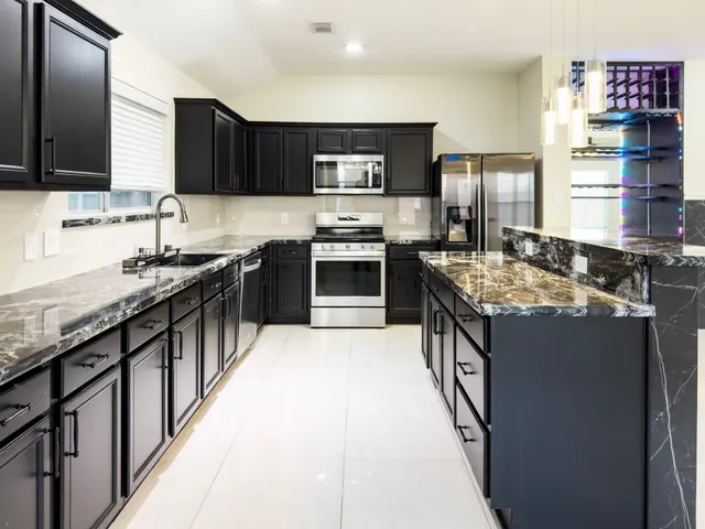 a kitchen with stainless steel appliances granite countertop a sink stove and refrigerator