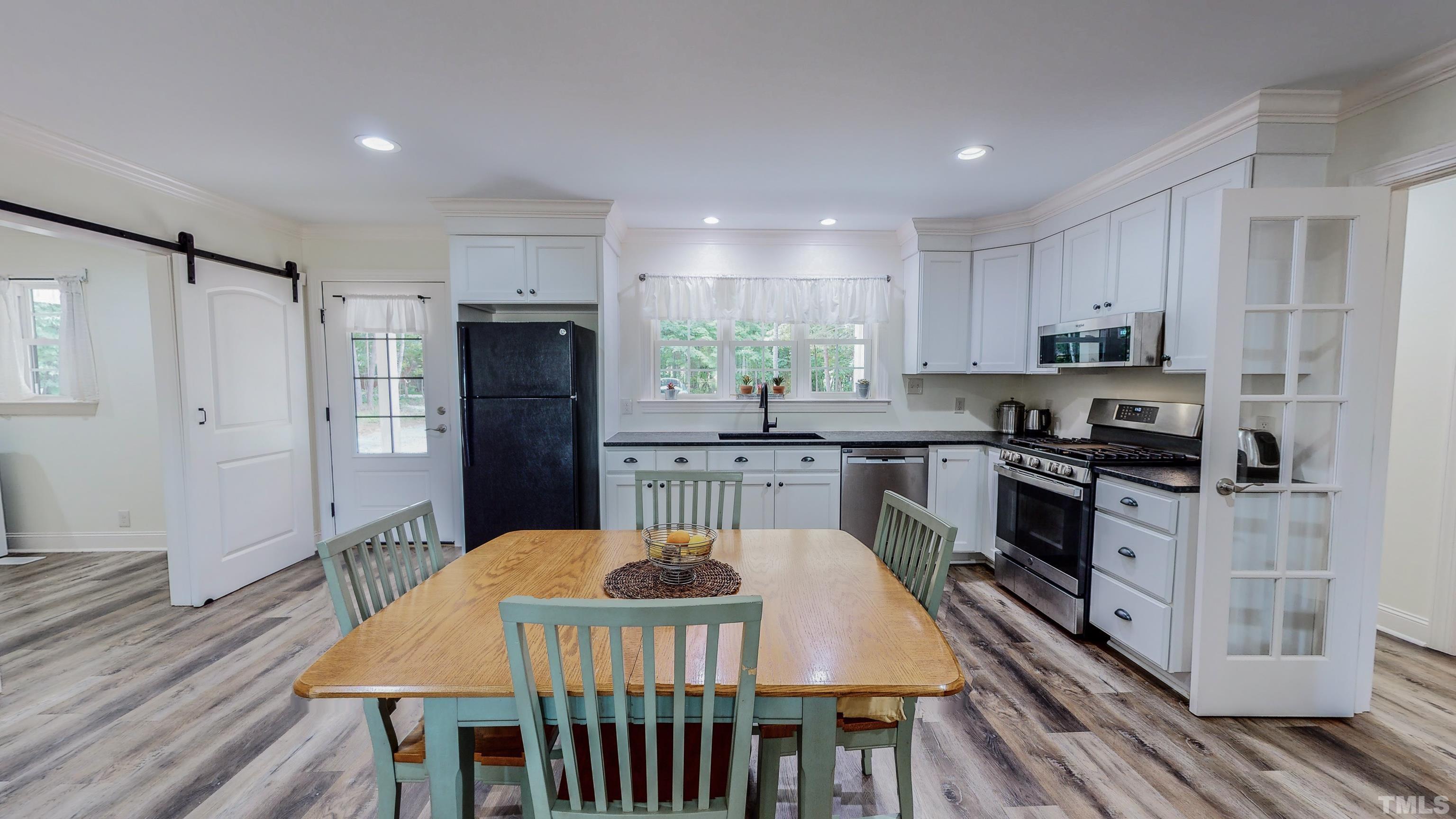 7402 Deer Crossing Road Rougemont, NC 27572 - Photo 11 of 54 a kitchen with stainless steel appliances granite countertop a stove a refrigerator a kitchen island a dining table and chairs