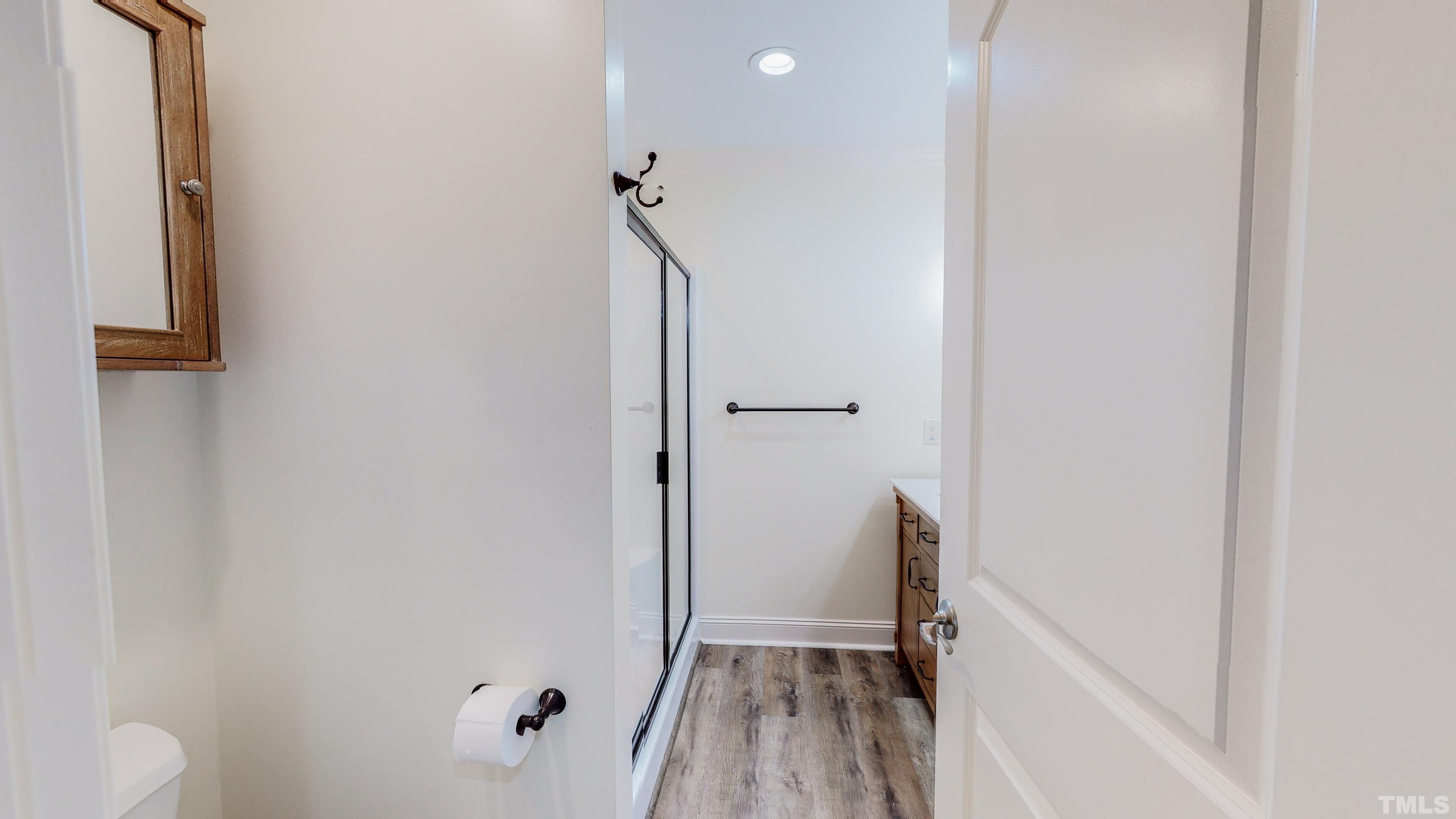 7402 Deer Crossing Road Rougemont, NC 27572 - Photo 16 of 54 a view of a hallway with wooden floor and a bathroom