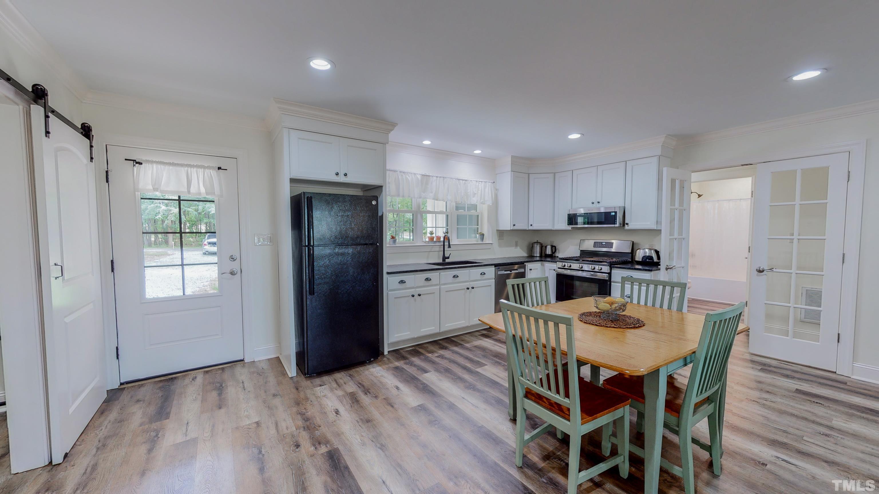 7402 Deer Crossing Road Rougemont, NC 27572 - Photo 2 of 54 a kitchen with stainless steel appliances granite countertop a refrigerator a stove a sink a microwave and island with wooden floor