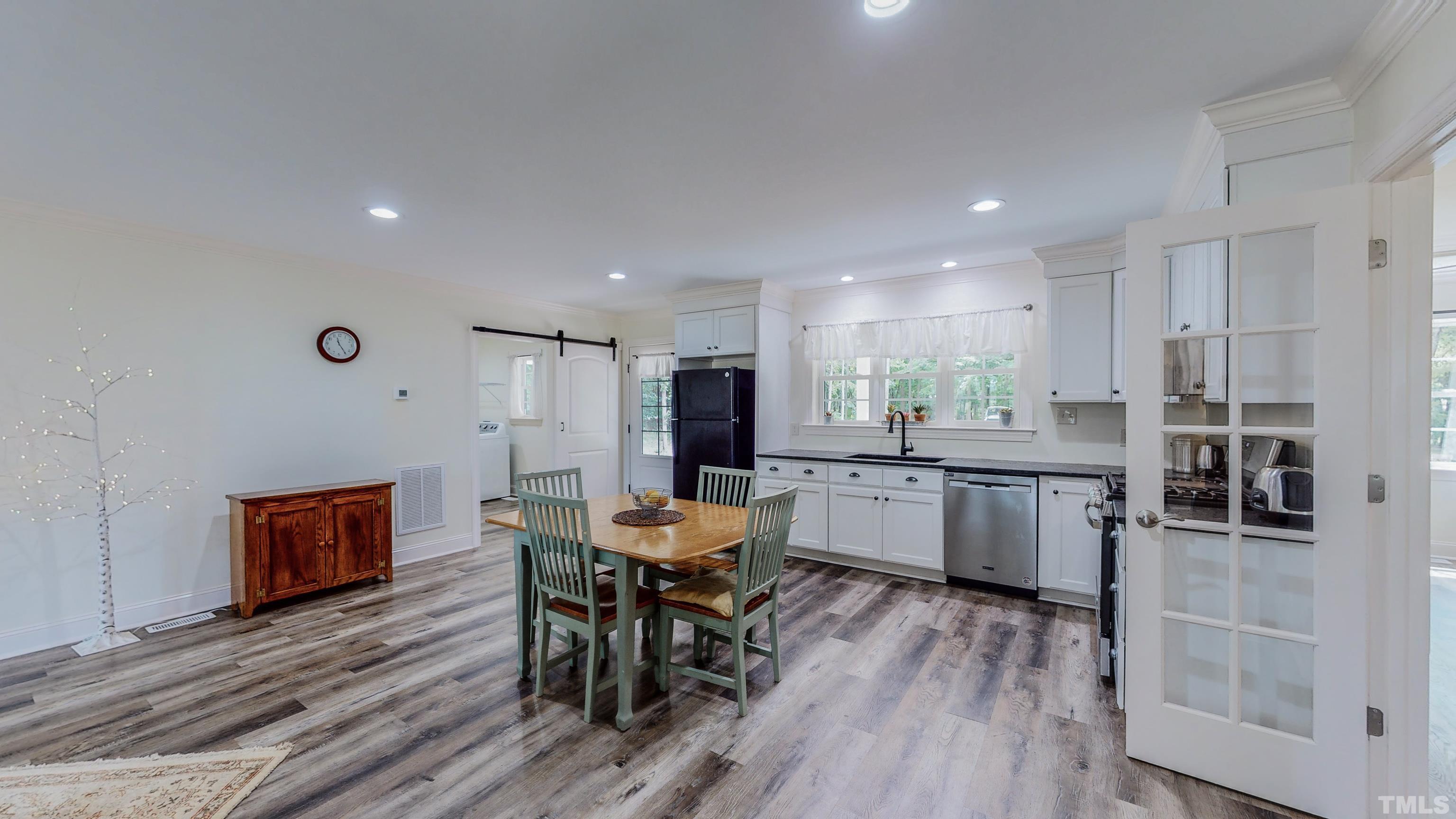 7402 Deer Crossing Road Rougemont, NC 27572 - Photo 21 of 54 a kitchen with stainless steel appliances kitchen island granite countertop a table chairs stove microwave and cabinets