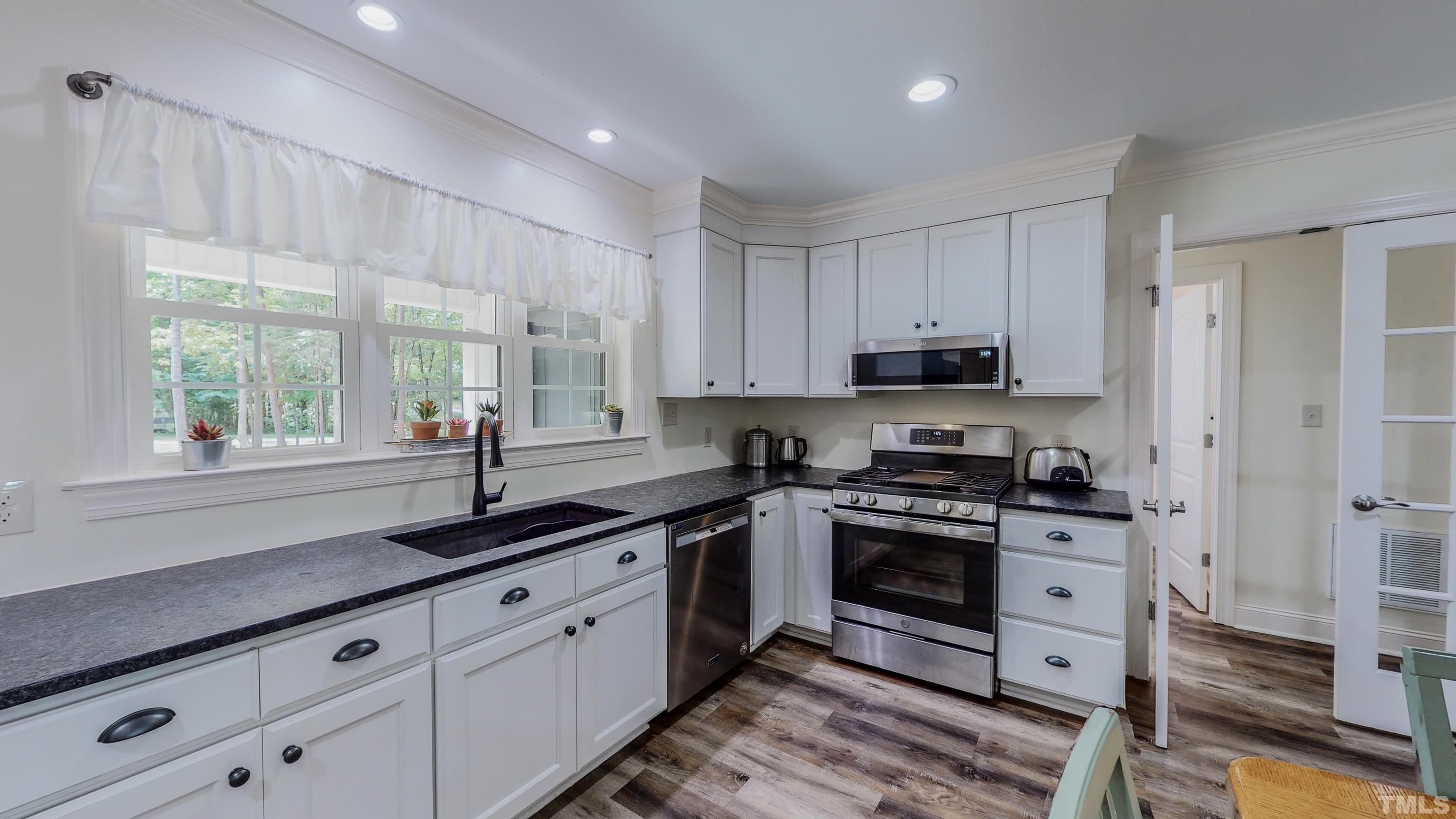 7402 Deer Crossing Road Rougemont, NC 27572 - Photo 4 of 54 a kitchen with granite countertop white cabinets and appliances