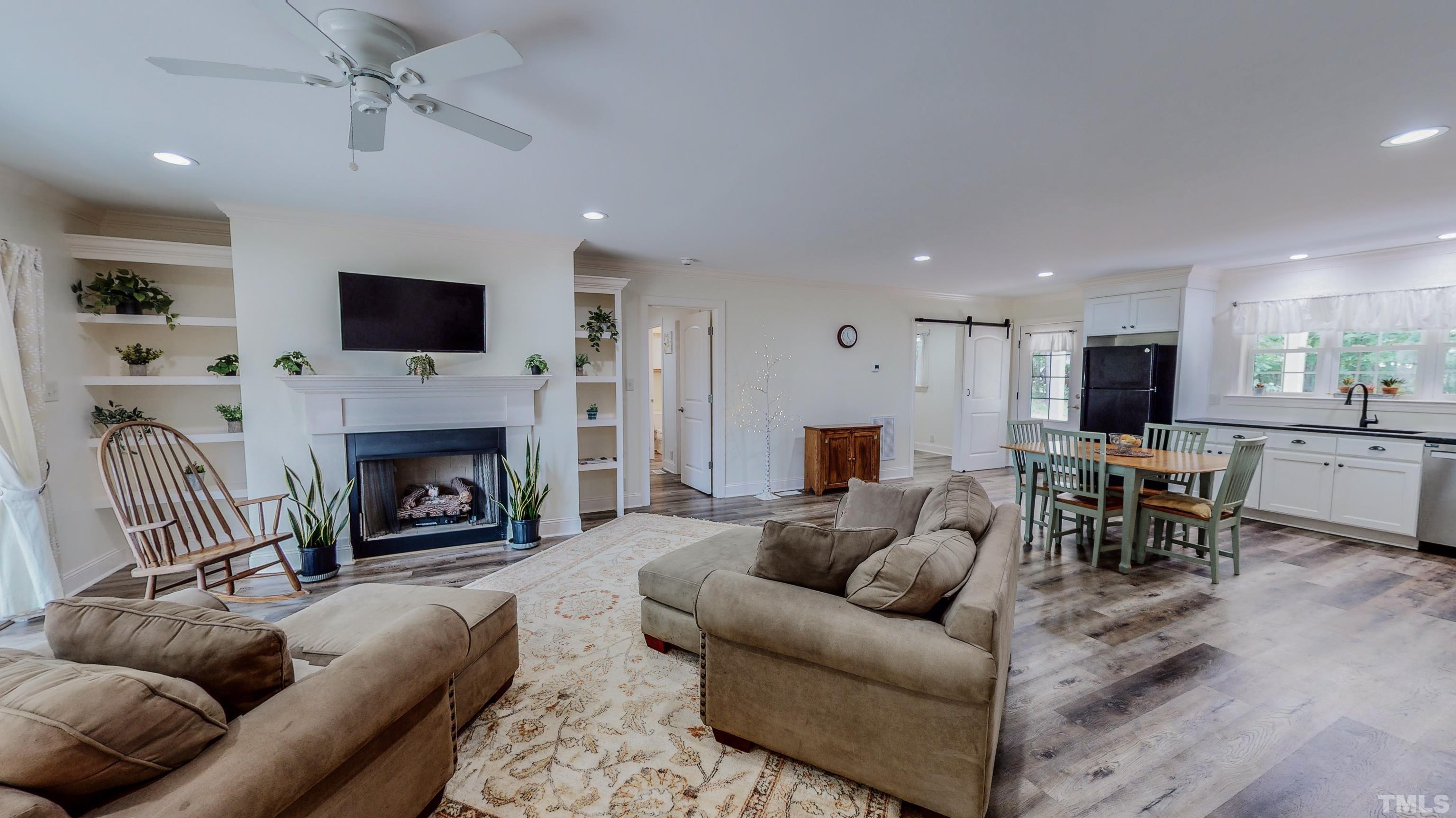 7402 Deer Crossing Road Rougemont, NC 27572 - Photo 5 of 54 a living room with furniture a fireplace and a flat screen tv