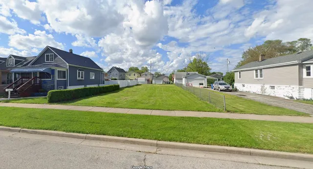a view of a big house with a big yard and large trees