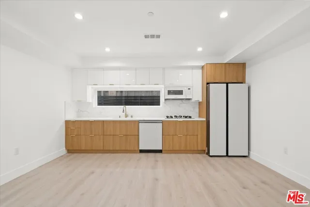 a kitchen with stainless steel appliances granite countertop a stove a sink and a refrigerator